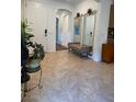 Inviting foyer showcasing neutral tiling, a bench with mirror, and an open archway leading to other spaces at 6756 Millbury St, North Las Vegas, NV 89086