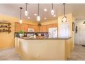 Bright kitchen with light wood cabinets, granite countertops, and modern appliances at 7824 Homing Pigeon St, North Las Vegas, NV 89084