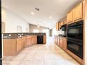 Well-equipped kitchen with wood cabinets, granite countertops, and tile flooring at 8161 Cane Creek Mill Ct, Las Vegas, NV 89131