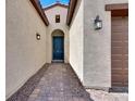 Covered entryway with a blue front door framed by stylish lanterns and brick walkway at 851 Klamath Springs St, Henderson, NV 89011