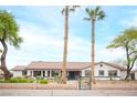 Inviting single-story home with manicured front yard, decorative wall, and mature palm trees at 8610 Mohawk St, Las Vegas, NV 89139