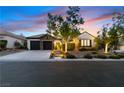 Charming home exterior with stone accents, a well-manicured front yard, and a two-car garage at 921 Granger Farm Way, Las Vegas, NV 89145