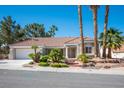 Lovely single-story home boasting mature palm trees, lush greenery, and a charming red tile roof at 9524 Quail Ridge Dr, Las Vegas, NV 89134