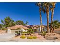 Inviting single-story home featuring desert landscaping and beautiful tall palm trees at 9524 Quail Ridge Dr, Las Vegas, NV 89134