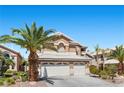 Two-story home with a two-car garage and desert landscaping at 283 Grand Olympia Dr, Henderson, NV 89012