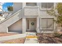 Condo with white stucco exterior and front door adorned with a wreath at 3425 E Russell Rd # 155, Las Vegas, NV 89120