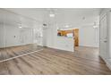 Open-concept living room with wood-look floors, neutral walls and view of kitchen at 3425 E Russell Rd # 155, Las Vegas, NV 89120
