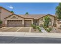 Inviting single-story home featuring a well-manicured front yard and a two-car garage at 521 Dawn Cove Dr, Henderson, NV 89052
