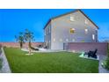 Inviting backyard with artificial turf, mature trees, a brick perimeter fence, and outdoor seating at 5368 Knitmore Ct, Las Vegas, NV 89139