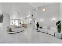 Open-concept living area with stylish furniture, marble floors and modern lighting fixtures at 9155 Bush Poppy Ave, Las Vegas, NV 89147