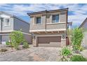 Charming two-story home featuring a paver driveway, attached two car garage and neutral exterior at 10038 W Meranto Ave, Las Vegas, NV 89178