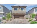 Charming two-story home featuring a paver driveway, attached two car garage and neutral exterior at 10038 W Meranto Ave, Las Vegas, NV 89178