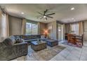 Spacious living room with a plush sectional sofa, ceiling fan, and ample natural light at 10042 Bismuth St, Las Vegas, NV 89183