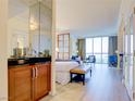 Bright bedroom with kitchenette, wood floors, king bed, sitting area, and stunning city view through large windows at 135 E Harmon Ave # 804, Las Vegas, NV 89109