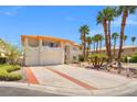 Long driveway leading up to this elegant two-story home featuring a tile roof and palm trees at 1840 Myrtle Island Dr, Las Vegas, NV 89117
