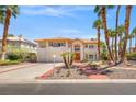 Elegant two-story home featuring a tile roof, palm trees, and an inviting walkway at 1840 Myrtle Island Dr, Las Vegas, NV 89117