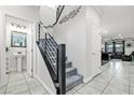 Bright hallway with modern staircase, leading to a half bathroom and open living space at 2127 Brewer Ave, North Las Vegas, NV 89081