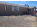Side exterior shot with tan siding, a small covered porch with chairs, and minimal landscaping at 3451 Ramona Ln, Pahrump, NV 89048