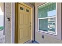 Close-up of a yellow front door with a window showing a reflection of a vehicle outside at 4145 Lunar Canyon Ave, North Las Vegas, NV 89084