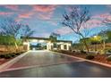 A beautifully landscaped entrance featuring a brick-paved drive and elegant gate with accent lighting at 4193 Solace St # 4193, Las Vegas, NV 89135