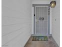 Close-up of the front door featuring security gate, door number, welcome mat, and outdoor light fixture at 468 Potomac St, Henderson, NV 89015