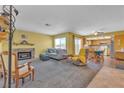 A spacious living room featuring neutral carpet, a stone fireplace, and an open floor plan at 468 Potomac St, Henderson, NV 89015