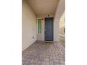 Covered entryway with brick-paved porch leading to a modern front door with window and lantern at 5419 Holding Ave, Las Vegas, NV 89139