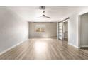 Spacious bedroom with a ceiling fan, a window and an accented wall design, along with wood-look floors at 5612 Coder Ct, Las Vegas, NV 89118