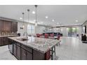 Open concept kitchen with island, granite countertops, stainless steel appliances, and backyard access at 6331 Regina Ridge St, Las Vegas, NV 89149