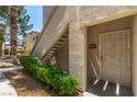 Condo entrance with security door and well-manicured hedges alongside outdoor steps at 6480 Annie Oakley Dr # 814, Las Vegas, NV 89120
