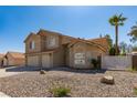 Two-story home with a three-car garage, rock landscaping, and desert climate plants at 723 Seclusion Glen Ave, Las Vegas, NV 89123