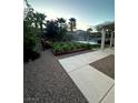 Lush backyard garden with blooming flowers and gravel pathway offers a serene outdoor space at 7451 Mystic Stream St, Las Vegas, NV 89131