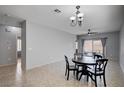 Open concept dining area with neutral colors, tiled floor, and sliding doors to backyard at 7732 Songster St, North Las Vegas, NV 89084
