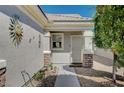 Inviting front entrance with decorative details, stone accents, and a charming sunburst wall decor at 7732 Songster St, North Las Vegas, NV 89084