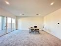 Versatile carpeted room featuring a sliding glass door and neutral walls at 80 Brixton Ave, Henderson, NV 89011