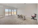 Spacious living room featuring large sliding glass doors and neutral carpeting at 80 Brixton Ave, Henderson, NV 89011