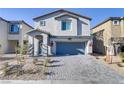 Charming two-story home with a blue front door, manicured landscaping, and a two-car garage at 8351 Gold River Ct, Las Vegas, NV 89113