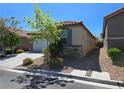 Well-kept home featuring a tile roof, desert landscaping, and a convenient two-car garage at 9463 Jumping Frog Ct, Las Vegas, NV 89147