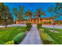 Well-manicured front yard and landscaping leading to front door at 9920 Rancho Destino Rd, Las Vegas, NV 89183