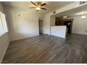 Spacious living room leading to kitchen with wood-look tile flooring and modern ceiling fan at 7701 W Robindale Rd # 127, Las Vegas, NV 89113