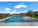 Inviting pool area with lounge chairs, serene landscaping, and a clear blue sky at 298 Watteau Ct, Henderson, NV 89012