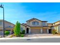 Inviting two-story home featuring a three-car garage and an attractive desert landscape at 3360 Lochside Dr, Henderson, NV 89044