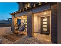 Inviting front porch with stylish egg chairs, brick pillars, and a modern front door with glass inserts at 395 Prairie Sun St, Las Vegas, NV 89138
