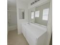Bright bathroom featuring a large mirror, a bathtub with shower, and white cabinets at 520 Shire Hall St, Las Vegas, NV 89178
