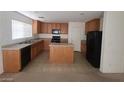 Bright kitchen featuring wooden cabinets, an island, and black appliances providing ample counter space at 520 Shire Hall St, Las Vegas, NV 89178