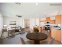 Open-concept living area with natural light, dining space and kitchen with stainless steel appliances at 909 Trinity Pond Cir, Henderson, NV 89002