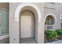 The covered entrance features a private front door, enhanced by attractive architectural details and landscaping at 10001 Peace Way # 2277, Las Vegas, NV 89147
