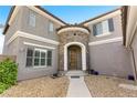 Charming home exterior featuring a stone accented entryway and manicured gravel landscaping at 10013 Scenic Walk Ave, Las Vegas, NV 89149