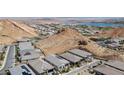 High aerial view showcasing desert landscaping, the community, nearby lake and multi-story homes at 12 Tatahatso Point St, Henderson, NV 89011
