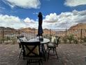 This home's outdoor patio set includes four chairs with cushions, a round table, umbrella and mountain views at 12 Tatahatso Point St, Henderson, NV 89011